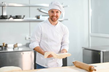 Adam makarna mutfak masasının üzerine hazırlanıyor.