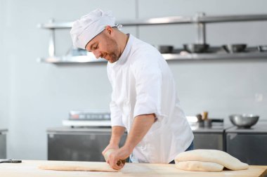 Adam makarna mutfak masasının üzerine hazırlanıyor.