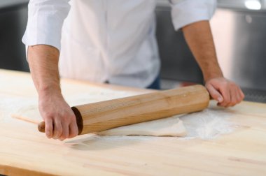 Adam makarna mutfak masasının üzerine hazırlanıyor.