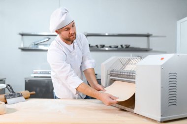 İşine odaklan. Makarna makinesinde hamuru yuvarlayan yakışıklı şef..