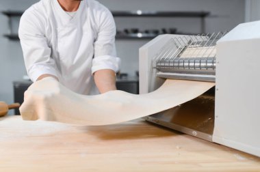 Adam makarna mutfak masasının üzerine hazırlanıyor.