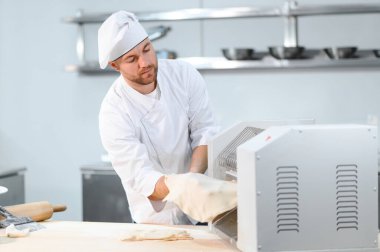 Adam makarna mutfak masasının üzerine hazırlanıyor.