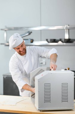 Adam makarna mutfak masasının üzerine hazırlanıyor.