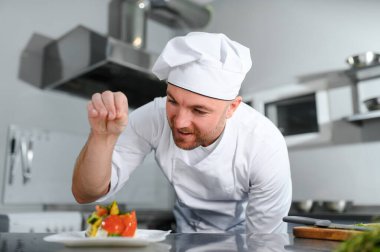 Kafkasyalı mutlu aşçının portresi restoranın mutfağında duruyor..