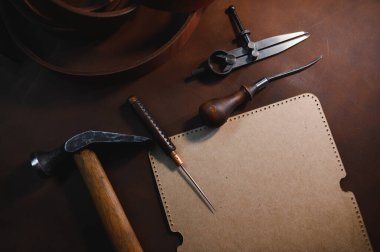 Tools for leather craft on leather backgroung. clipart