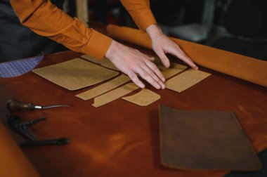 Terzi turtası farklı rulo tutuyor. Doğal kahverengi deri, atölyede tekstil ile çalışıyor. Sanayi Sanayi Sanayi İşletme Ustası.