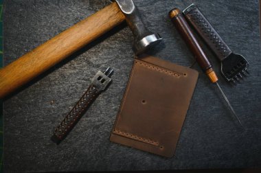 Tools for leather craft on leather backgroung. clipart