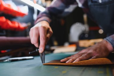 Terzi turtası farklı rulo tutuyor. Doğal kahverengi deri, atölyede tekstil ile çalışıyor. Sanayi Sanayi Sanayi İşletme Ustası.