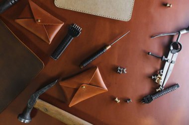 Terzi atölyesindeki doğal inek derisi üzerine el işi aletleri. Üst görünüm.