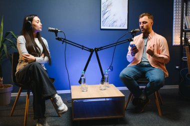 Profesyonel mikrofonlarla kayıt yaparken podcast röportaj yapan başarılı kadının yan görünümü, kopyalama alanı.