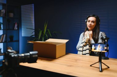 Dişi bir vlogger kameraya yeni şık giysiler yerleştiren bir video kaydediyor..