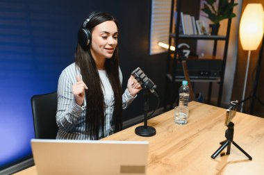 Pozitif kadın video kaydedicisi masada otururken kameraya kaydediyor..