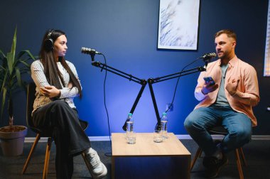 Canlı yayında sunucu kadınla röportaj yapıyor, moda ve tarz trendleri hakkında konuşuyor, fikirlerine katılmıyor. Adam sosyal medya ünlüleriyle tartışıyor, podcast kaydediyor.