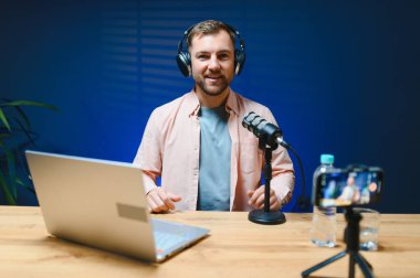 A video blogger records content in his studio. The host of the video blog is a young man who is very enthusiastic about telling his subscribers a story. clipart