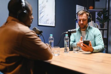 Podcast sunucusu adamla canlı yayında tartışıyor, izleyiciler için internet eğlence programında yayınlıyor. Etkilenen konuk ile sohbet etmek, kişisel ev stüdyosunda yayın yapmak