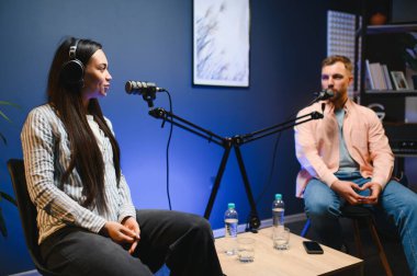 Canlı yayında sunucu kadınla röportaj yapıyor, moda ve tarz trendleri hakkında konuşuyor, fikirlerine katılmıyor. Adam sosyal medya ünlüleriyle tartışıyor, podcast kaydediyor.