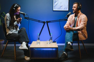 Canlı yayında sunucu kadınla röportaj yapıyor, moda ve tarz trendleri hakkında konuşuyor, fikirlerine katılmıyor. Adam sosyal medya ünlüleriyle tartışıyor, podcast kaydediyor.