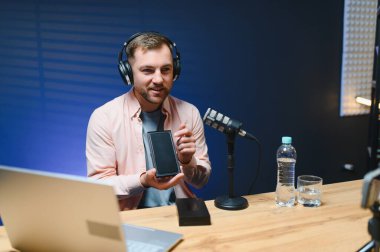 Kanal için online içerik oluşturan genç bir adam, günlük vlog, evde yepyeni bir telefon açmak, çevrimiçi satışlar.