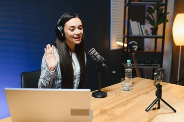 Smiling young caucasian girl woman making a video blog (vlog) with camera clipart