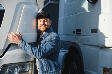 Kafkasyalı kamyon şoförü işini seviyor. Kamyoncu taşıma için aracına sarılıyor..