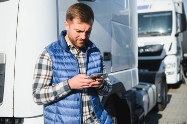 Kamyonetinin önünde duran kendinden emin mutlu erkek sürücü..