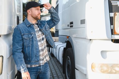 Kamyonun önünde duran kendinden emin erkek sürücü..