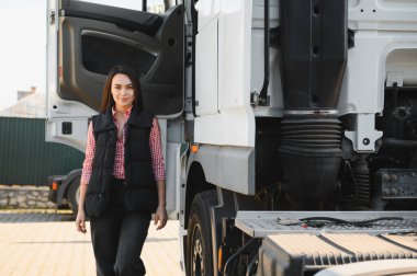 İlk turunu başarıyla tamamladıktan sonra kamyonetinin önünde duran kadın kamyon şoförü..