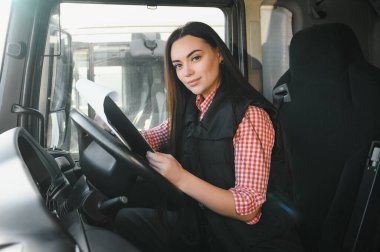 Kamyon şoförü kadın. Kamyon kabininde elinde dosya var. Aracın içinde. İnsanlar ve ulaşım kavramı.