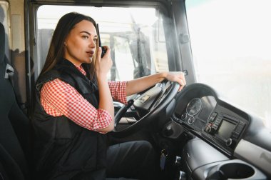 Kamyon şoförü kadın kabinin içinde telsizle konuşuyor. Kadın kamyon şoförü..