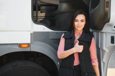 İlk turunu başarıyla tamamladıktan sonra kamyonetinin önünde duran kadın kamyon şoförü..