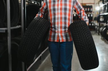 Lastik tamir servisi. Bir adam arabası için yeni lastikler seçer.