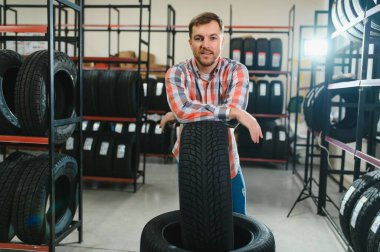 Lastik tamir servisi. Bir adam arabası için yeni lastikler seçer.