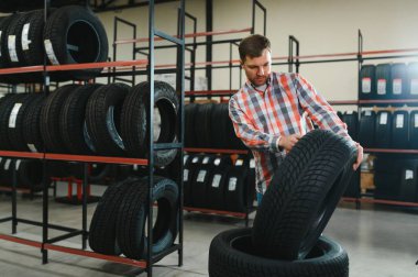 Akıllı erkek müşteri süpermarkette satın almak için yeni lastik seçimi. Araba mal ile büyük alışveriş merkezi.