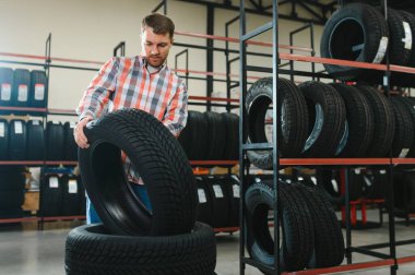 Lastik tamir servisi. Bir adam arabası için yeni lastikler seçer.