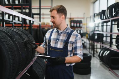 Lastiği olan profesyonel bir işçi. Lastik tamir servisinde adam var..