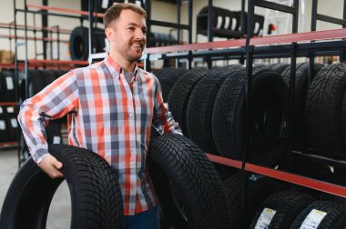Lastik tamir servisi. Bir adam arabası için yeni lastikler seçer.