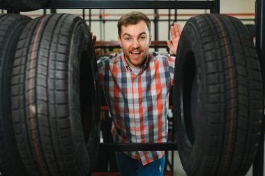 Lastik tamir servisi. Bir adam arabası için yeni lastikler seçer.