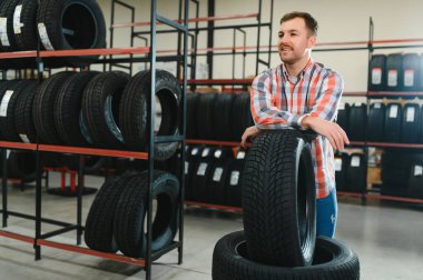 Lastik tamir servisi. Bir adam arabası için yeni lastikler seçer.