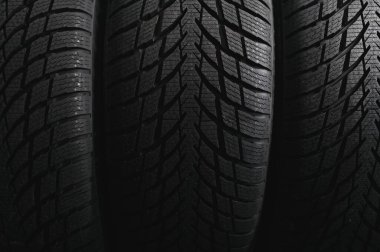 Araba lastiği dükkânı konsepti, yeni araba lastiği ve arka planda yığılmış lastik ve metin için fotokopi alanı.