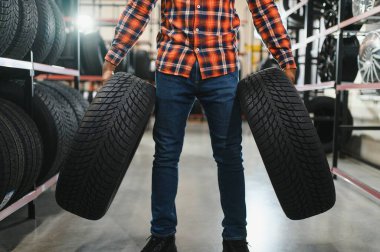 Akıllı erkek müşteri süpermarkette satın almak için yeni lastik seçimi. Araba mal ile büyük alışveriş merkezi.