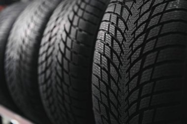 Araba lastiği dükkânı konsepti, yeni araba lastiği ve arka planda yığılmış lastik ve metin için fotokopi alanı.