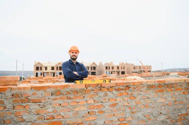 Construction worker in uniform and safety equipment have job on building. Industrial theme.