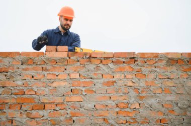 Construction worker in uniform and safety equipment have job on building. Industrial theme.