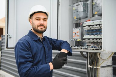 Elektrik mühendisi güç dağıtım kutusu kurulumunu onaylıyor.