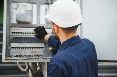 Neşeli elektrikçi dışarıda elektrik santrali kuruyor..