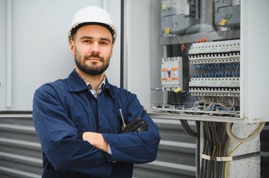 Elektrik mühendisi güç dağıtım kutusu kurulumunu onaylıyor.