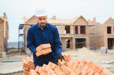 Construction worker in uniform and safety equipment have job on building. Industrial theme.