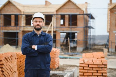 Construction worker in uniform and safety equipment have job on building. Industrial theme.