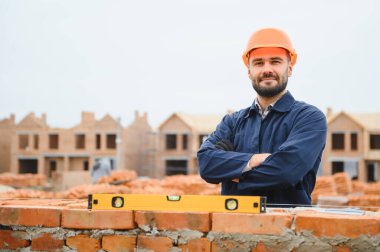 Açık havada inşaat alanında çalışan bir inşaatçının portresi..