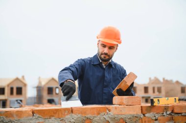 Açık havada inşaat alanında çalışan bir inşaatçının portresi..